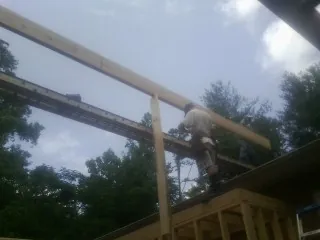 Carpenter setting a ridge beam over a new addition frame — Ice Dam Removal by Roofing Brothers in Hempstead