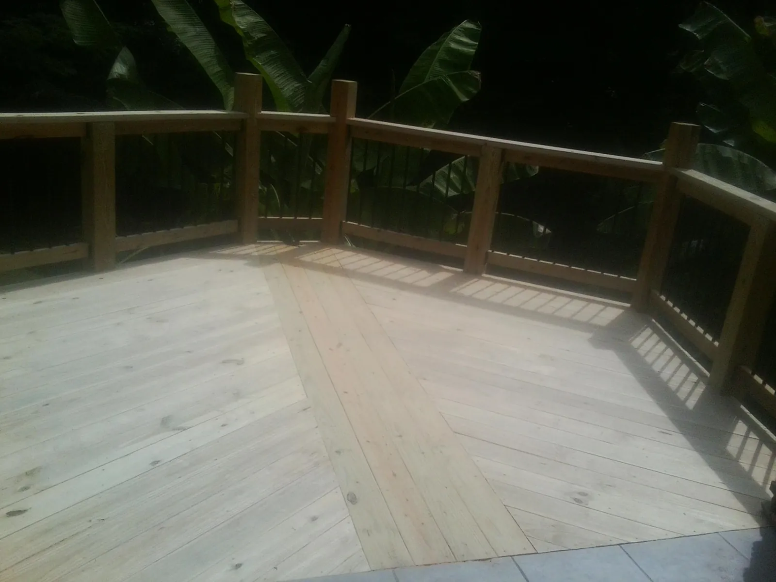 New wood deck and railing built off the back of a home in Hempstead