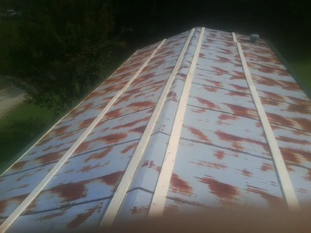 Rusted metal roof panels with new wood purlins before replacement — Storm Damage Roof Repair in Hempstead by Roofing Brothers